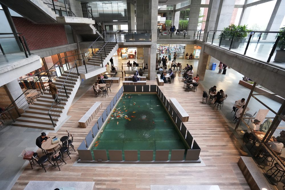 The central atrium of the UIU campus with students at tables around the pool